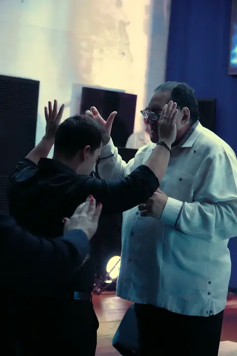 Pastor Samuel praying over a young man