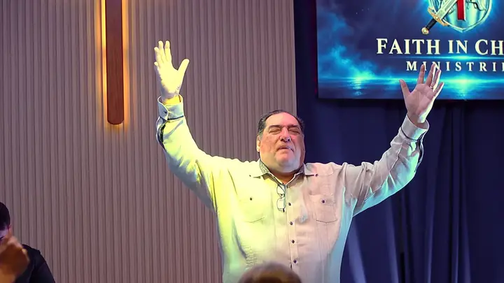 Pastor Samuel lifting his hands in praise