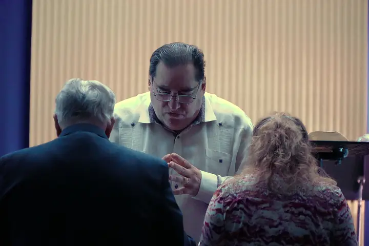 Pastor Samuel praying with a couple