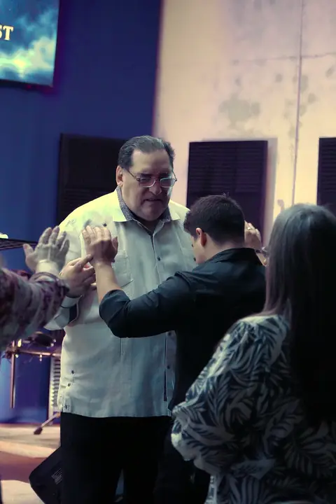The church gathered in prayer around a young man
