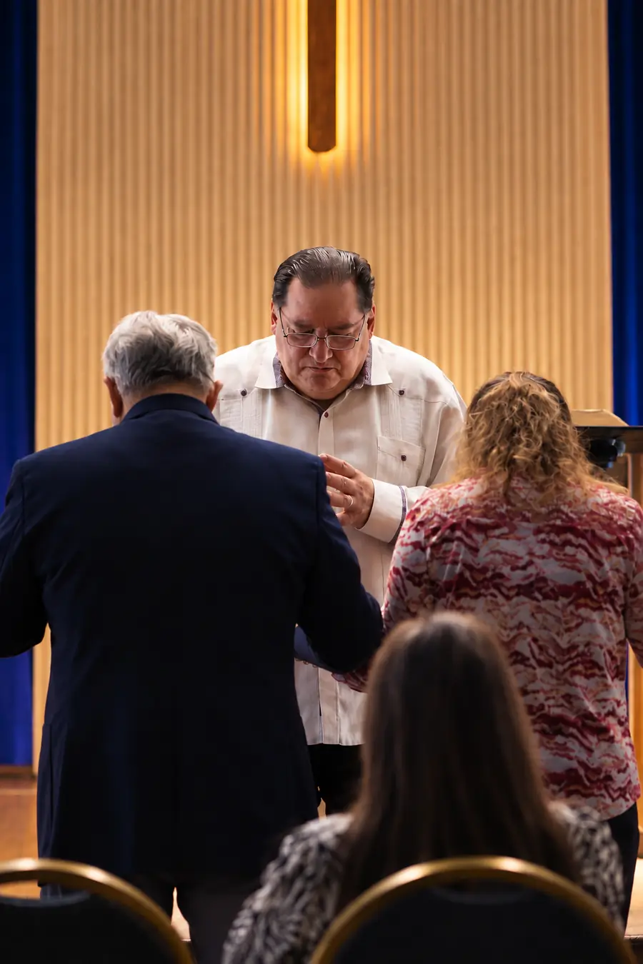 Pastor Samuel Tablada praying with members of the church
